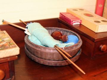 A basket with a knitting project inside it